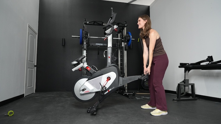 a person lifting an exercise bike