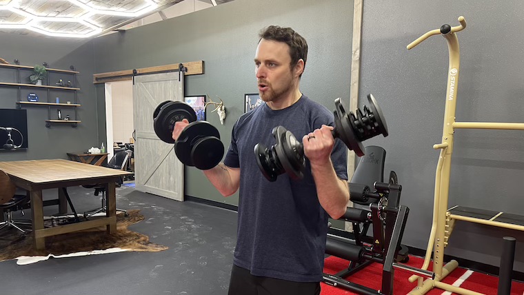 a person performing biceps curls with the FLYBIRD Adjustable Dumbbell