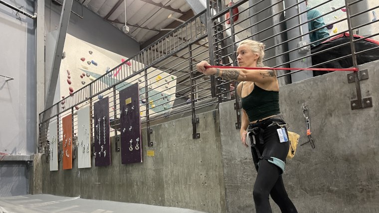 Our tester does a chest press with the red Titan Fitness Light Resistance Band