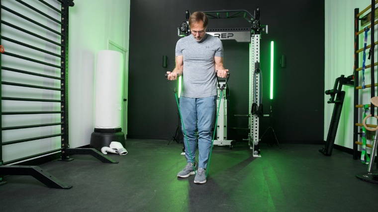 Our tester does bicep curls with the green band from a set of Rogue Tube Bands