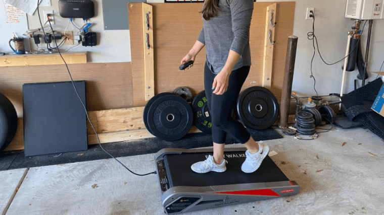 A woman walks on the Egofit Walker Pro in her garage gym