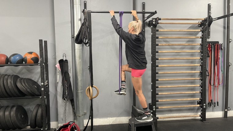 Woman uses a Fringe Sport Resistance Band for an assisted pullup