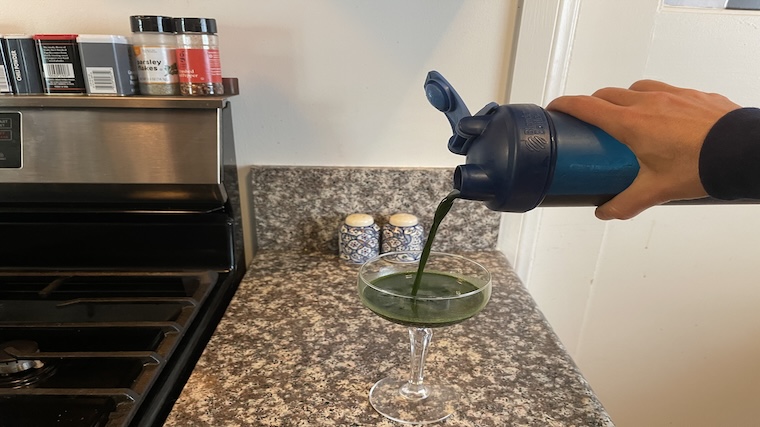 Our tester mixing and pouring a serving of 1st Phorm Opti-Greens 50 greens powder