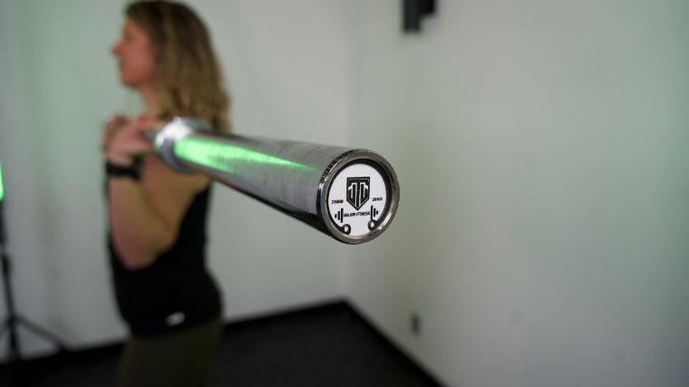 A close look at the end cap on a Major Fitness Barbell Advanced while our tester is using it