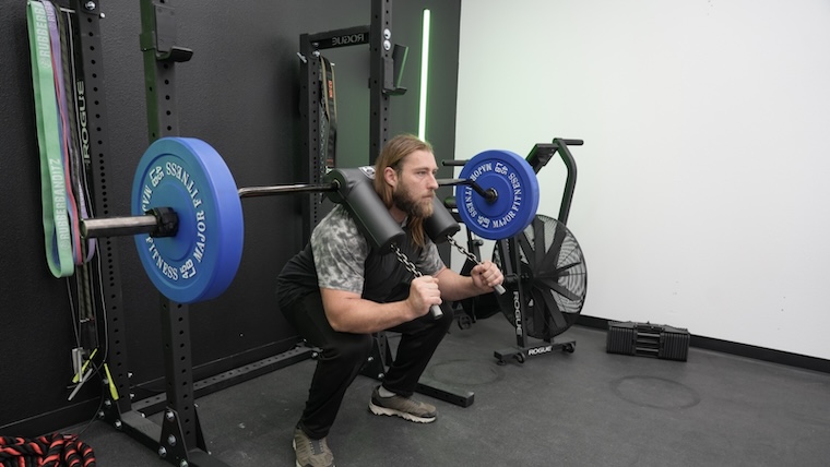 a person performing a barbell back squat