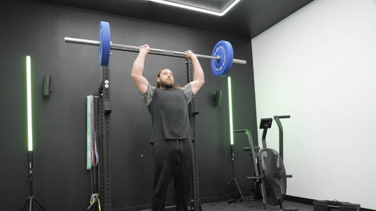 Our tester lifting a REP Fitness Double Black Diamond Bar above his head