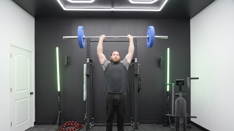 Our tester lifts a REP Fitness Double Black Diamond Bar above his head