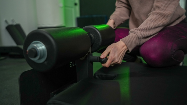 Our tester adjusts the leg holders on a Rogue Floor Glute machine