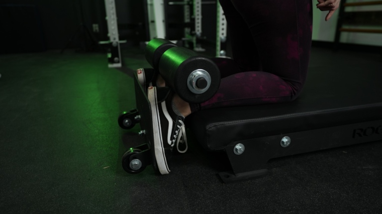 A close look at our tester using the leg holders on a Rogue Floor Glute machine