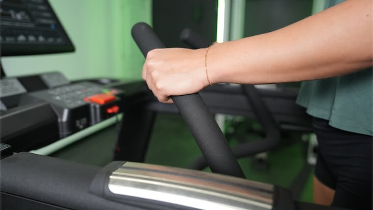 Our tester gripping the handles on the Xebex ST-6000 Treadmill.