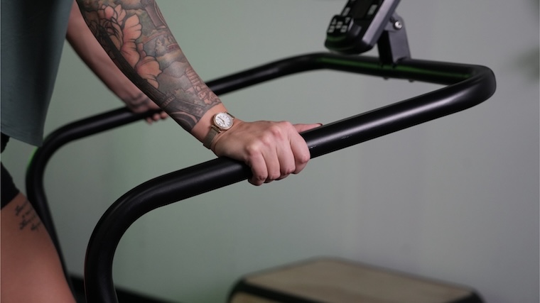 Our tester gripping the handrails of the Bells of Steel Wooden Residential Treadmill