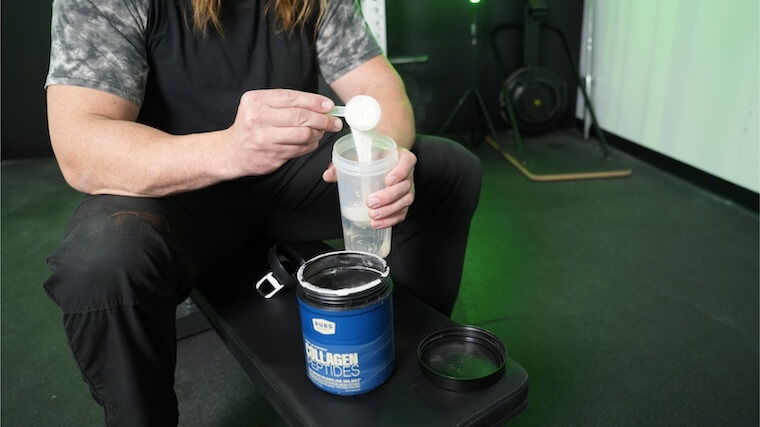 Our tester pouring a scoop of BUBS Naturals Collagen into their shaker bottle