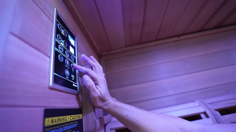 Our tester adjusting the settings on the Sun Home Luminar 5-Person Infrared Sauna