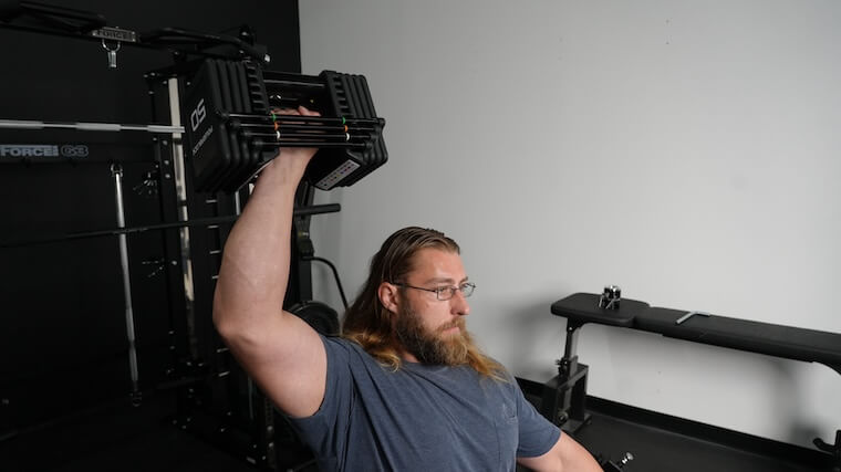 Our tester performing an overhead press with the PowerBlock Pro 100 EXP Adjustable Dumbbells