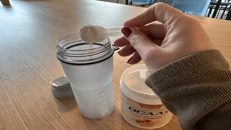 Our tester mixing a scoop of Snap Supplements BCAAs in a shaker bottle