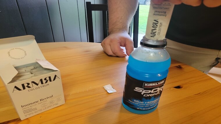 Our tester adding a packet of ARMRA Colostrum to their morning sports drink