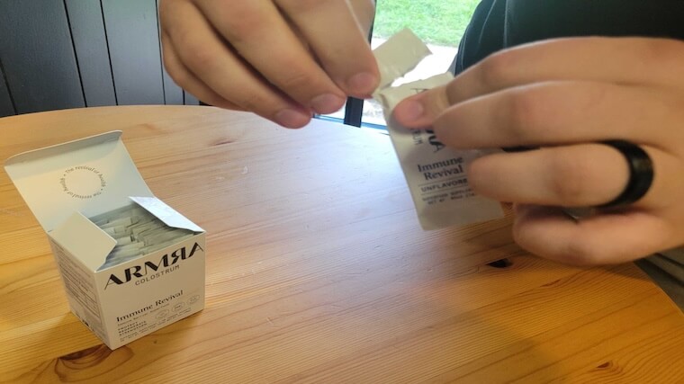 Our tester opening a travel-ready packet of ARMRA Colostrum