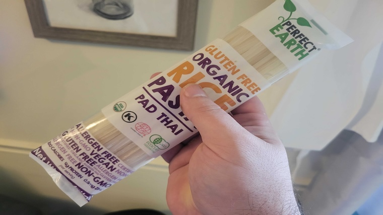Our tester holding a package of organic rice pasta as part of their Dinnerly meal delivery subscription