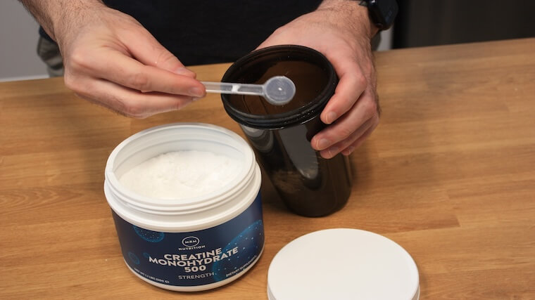 Our tester adding a scoop of MRM Nutrition Creatine to their shaker bottle