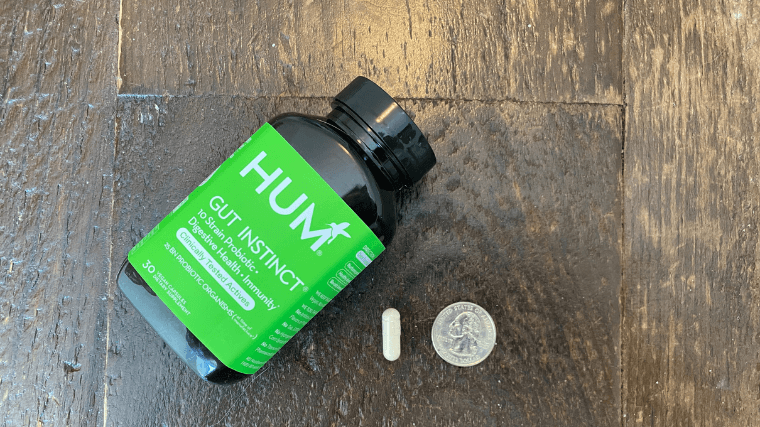 HUM Nutrition Gut Instinct capsule size in comparison to a standard quarter