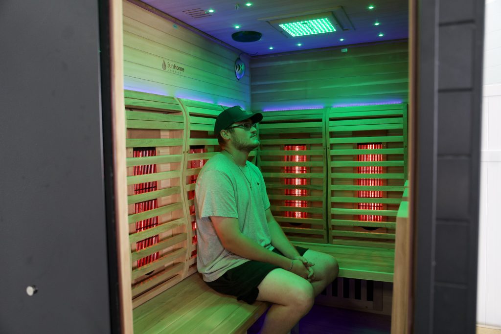 Tester sitting in the Sun Home Luminar 5 Person Sauna