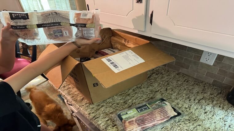 Our tester showcasing the chicken breasts delivered through their ButcherBox subscription