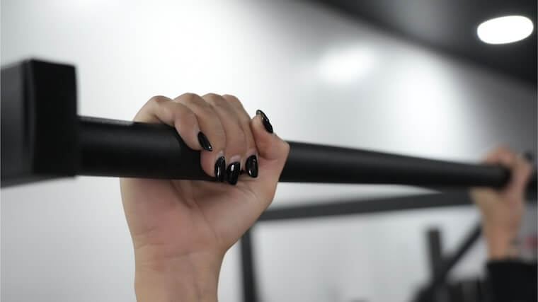 Our tester grabbing onto the Titan Fitness Wall-Mounted Pull-Up Bar