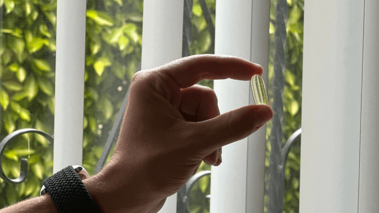 Our tester holding a single Nutricost Fish Oil capsule