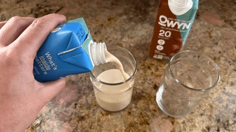 Our tester pouring an OWYN Vanilla Protein Shake into a glass