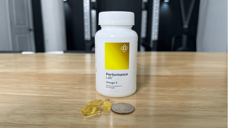 Performance Lab Omega-3 capsules compared to a standard coin