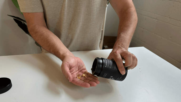 Our tester pouring Sports Research Omega-3 capsules into their hand
